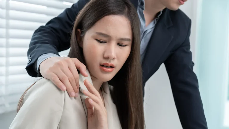 Uncomfortable woman reacting to a man's hand on her shoulder.