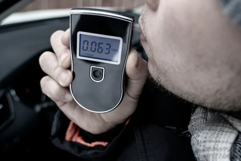 man blowing into a breathalyzer