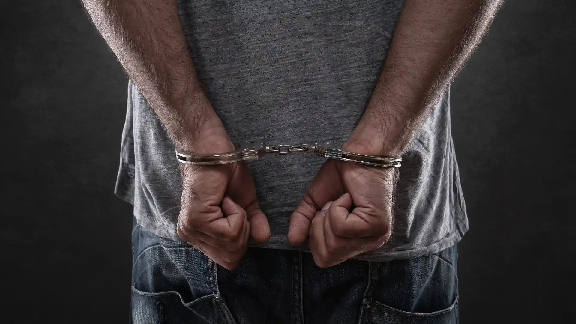 Man in handcuffs with hands behind back
